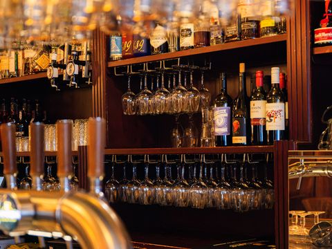 De bar van De Roemer met biertaps op de voorgrond en een wand vol glazen erachter.