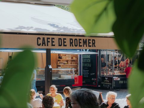 De gevel van Café de Roemer met de naam boven de ingang.