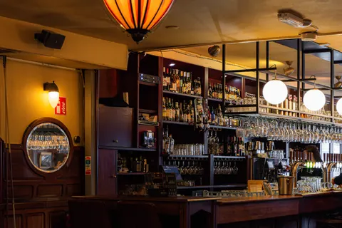 Het warme interieur en de lange bar in de avond.