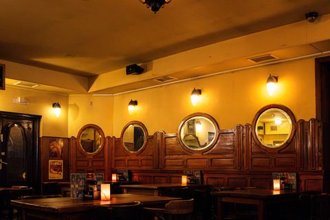 Het Roemertje met warme wanden, spiegels en gedekte tafels in het avondlicht.