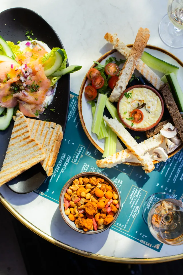Lunchbord met een geroosterd broodje en een schaaltje bitterballen, van bovenaf gefotografeerd.
